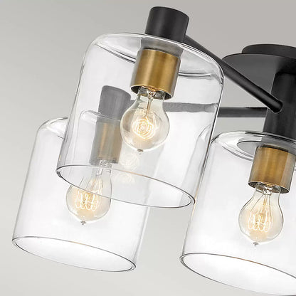  Hinkley Quintiesse Axel five-light semi-flush ceiling chandelier in matte black steel and heritage brass accents featuring clear glass globes mounted on a low ceiling.