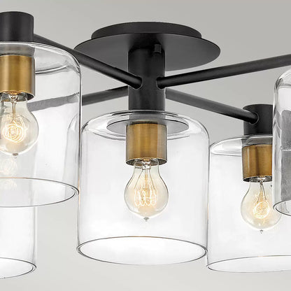 Hinkley Quintiesse Axel five-light semi-flush ceiling chandelier in matte black steel and heritage brass accents featuring clear glass globes mounted on a low ceiling.