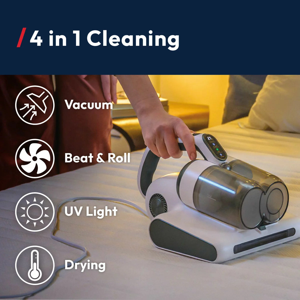 Front angle view of the compact grey Hoover 4-in-1 Mattress Vacuum Cleaner HMC510UV resting on a white quilted mattress surface, showcasing the LED display panel and roller brush base.