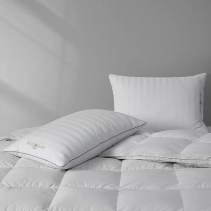 Hotel Grand Feather & Down Rolled Pillow 2 pack styled elegantly on a crisp white bed with silver piping details