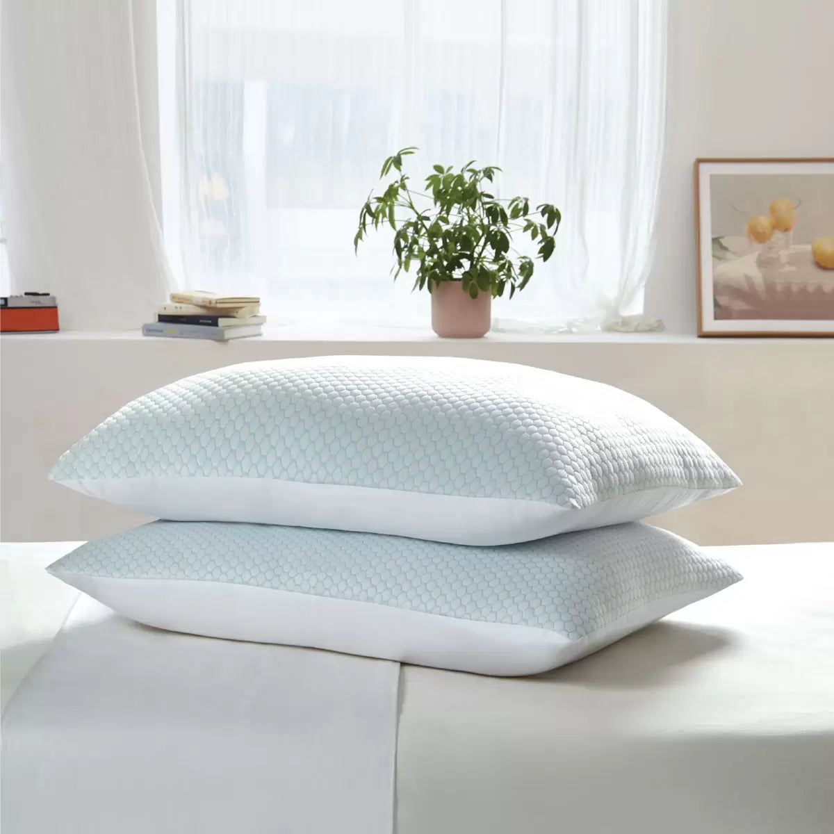 Pair of Hotel Grand reversible pillows resting on a bed displaying the blue-tinted cooling fabric side and white cotton finish.