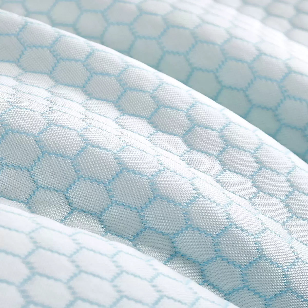 Pair of Hotel Grand reversible pillows resting on a bed displaying the blue-tinted cooling fabric side and white cotton finish.