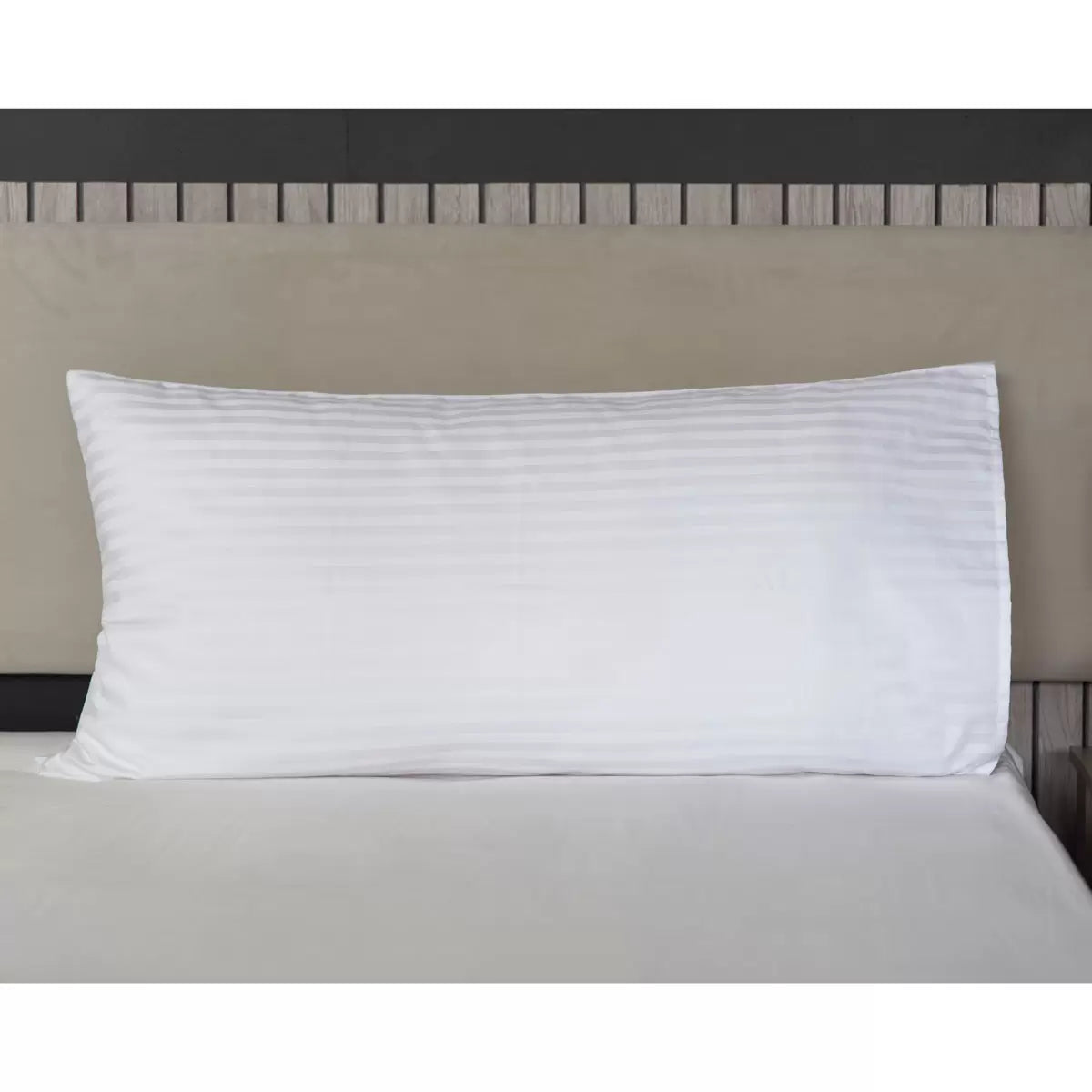 A close-up shot of two white sateen satin stripe Hotel Suite 540 thread count bolster pillowcases neatly arranged on a freshly made king-size bed.