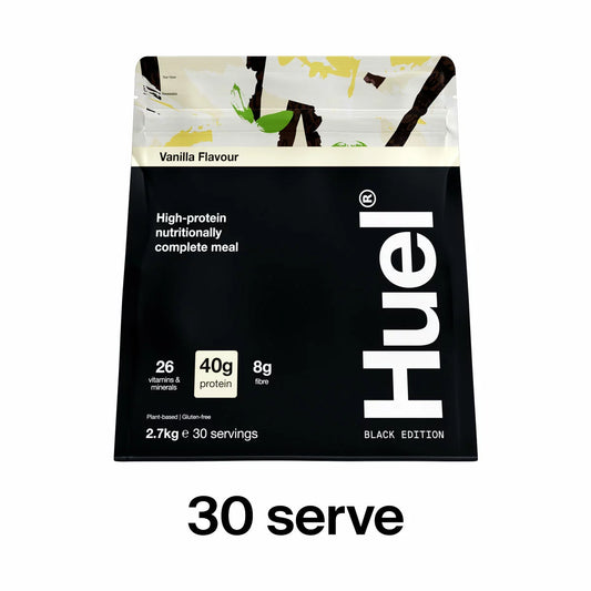 Black 2.7kg pouch of Huel Vanilla Black Edition complete meal powder alongside a filled shaker bottle on a clean kitchen counter.
