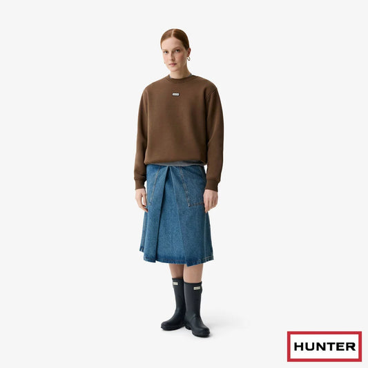 Hunter women's burgundy crewneck fleece sweater featuring ribbed cuffs and chest silicone badge displayed on a model in a natural setting.
