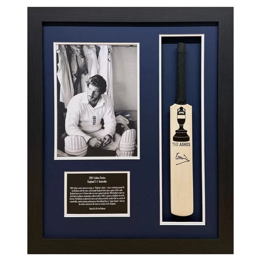A professional, large-format frame containing an authentic mini cricket bat signed by Lord Ian Botham, set against a clean, museum-style background.