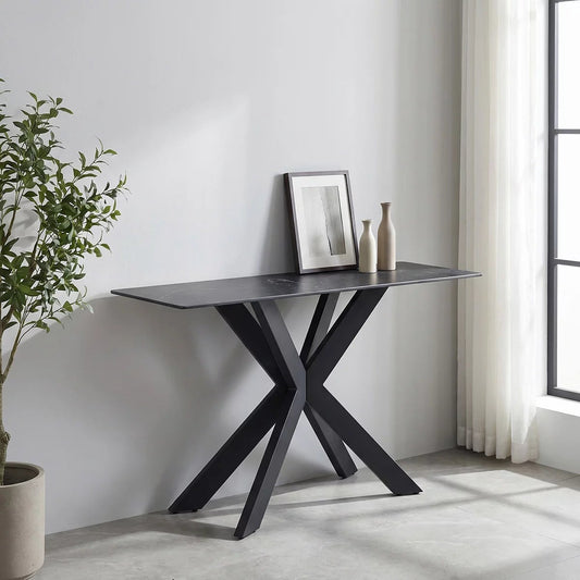 Black ceramic top console table with a slim rectangular profile and bold black iron base, shown at a slight angle against a light wall in a bright hallway styled with a lamp and a small decorative bowl.