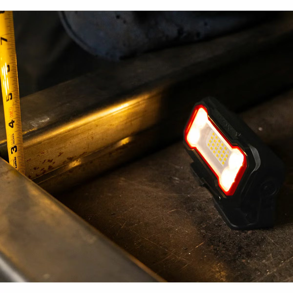 Three compact black and orange Infinity X1 rechargeable work lights displayed showing the 180-degree magnetic base, rear USB-C ports, and hanging clip.