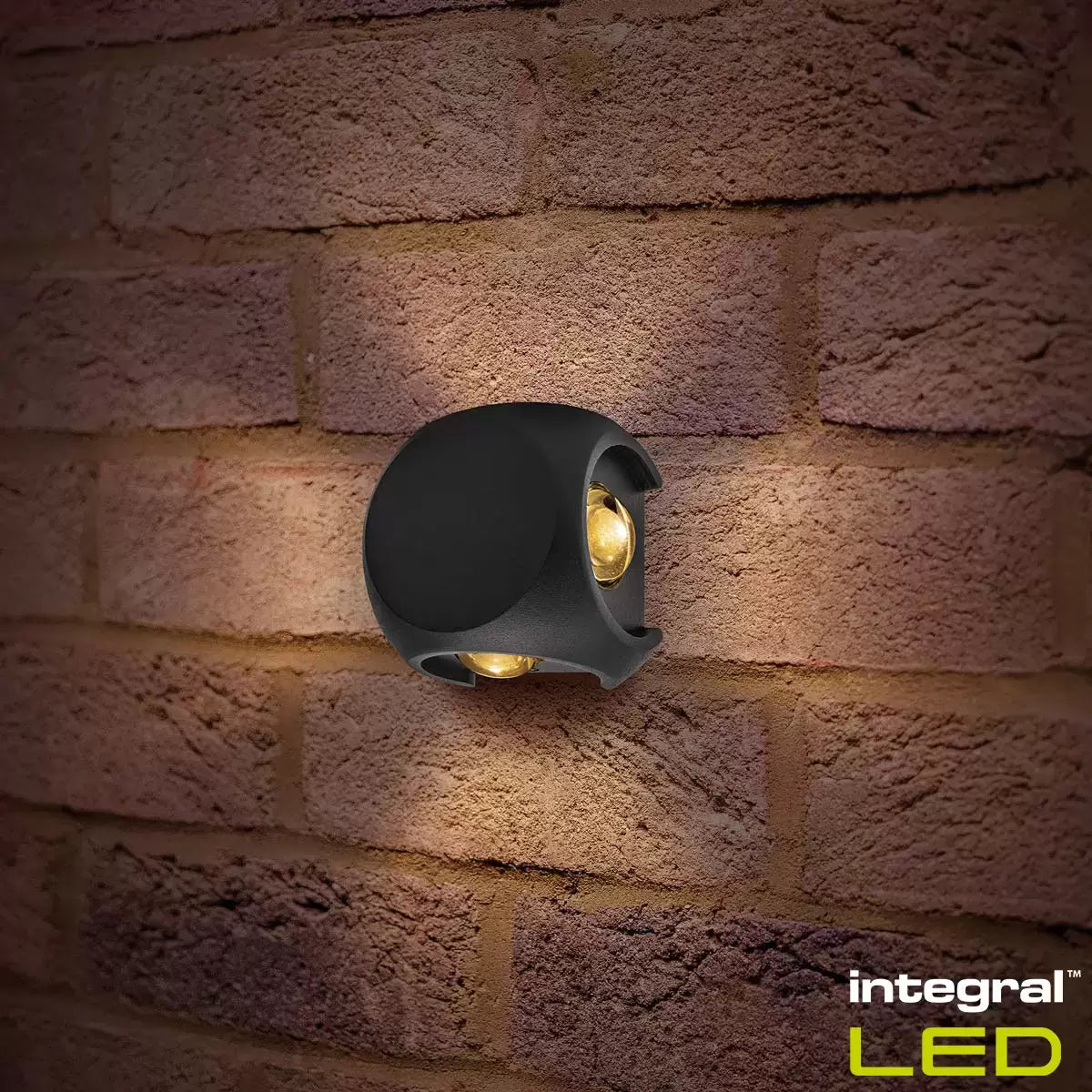 Pair of black Integral Crosscube 4-way outdoor wall lights projecting geometric cross-beams on a gray wall.