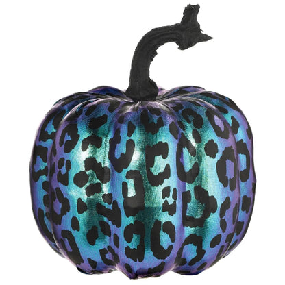 Close-up of an iridescent purple and black fabric pumpkin with a textured brown stem resting on a dark rustic wooden surface.