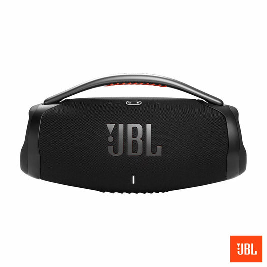 JBL Boombox 3 black portable Bluetooth speaker with sturdy metal handle and orange silicone grip resting on a wooden bench outdoors.