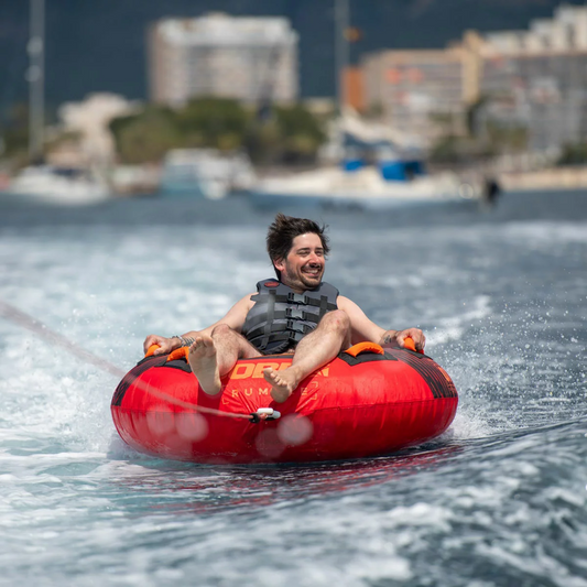Bright red Jobe Rumble 1 Person Inflatable Towable resting on a boat deck with visible neoprene handles and quick tow connector.