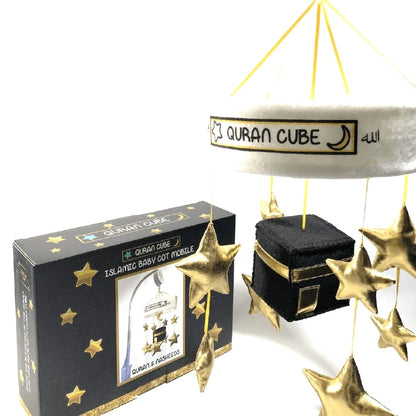 White baby cot mobile attached to a wooden crib rail featuring a plush central Kaaba surrounded by hanging golden stars and crescent moon plushies.