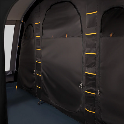 A green and grey Kampa Dawlish 4 Person Tunnel Tent pitched on a lush green grass campsite with its large side door open revealing the darkened inner sleeping compartment.