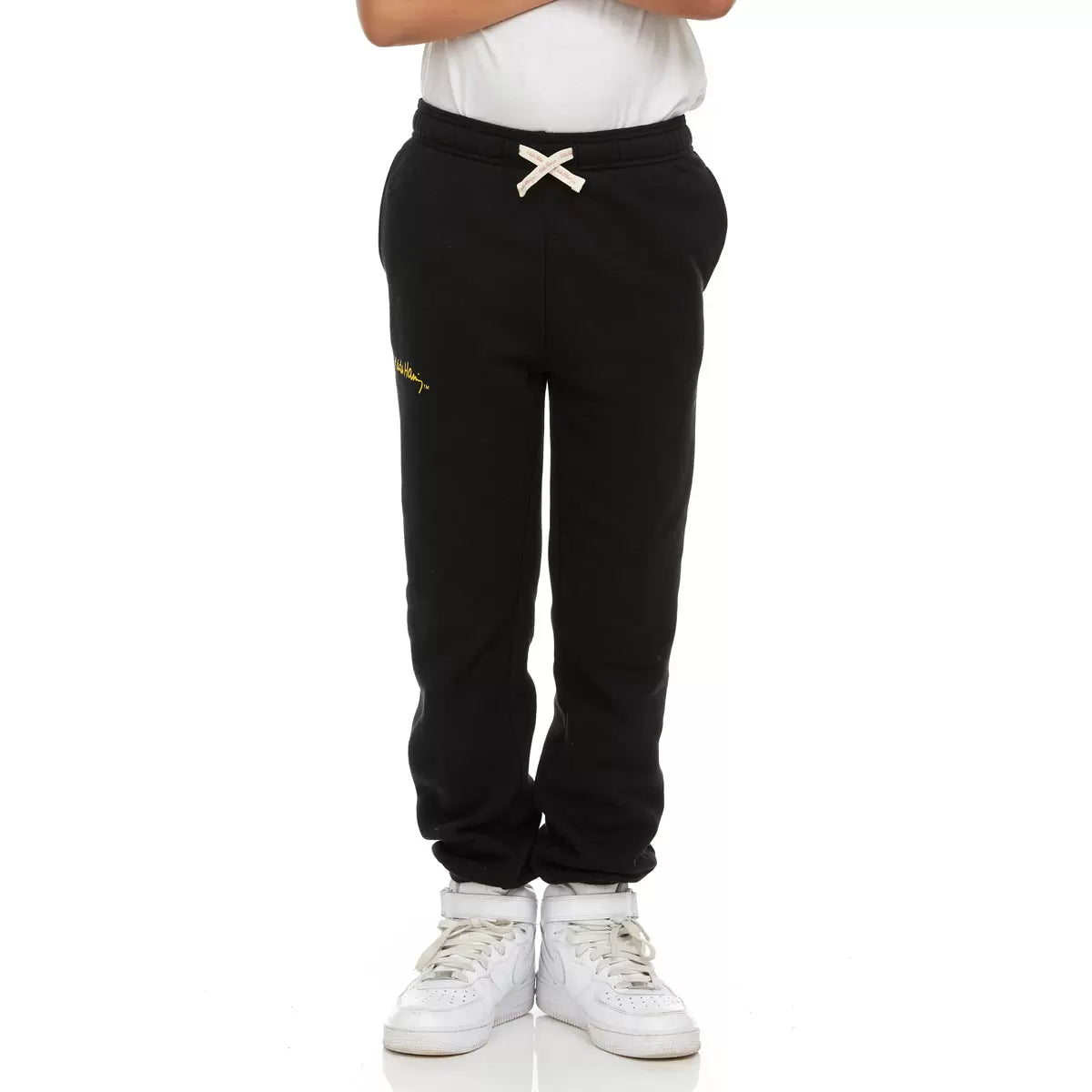 Front view of Keith Haring youth fleece joggers in green showing iconic pop art graphics, side pockets, and an elastic drawstring waistband.