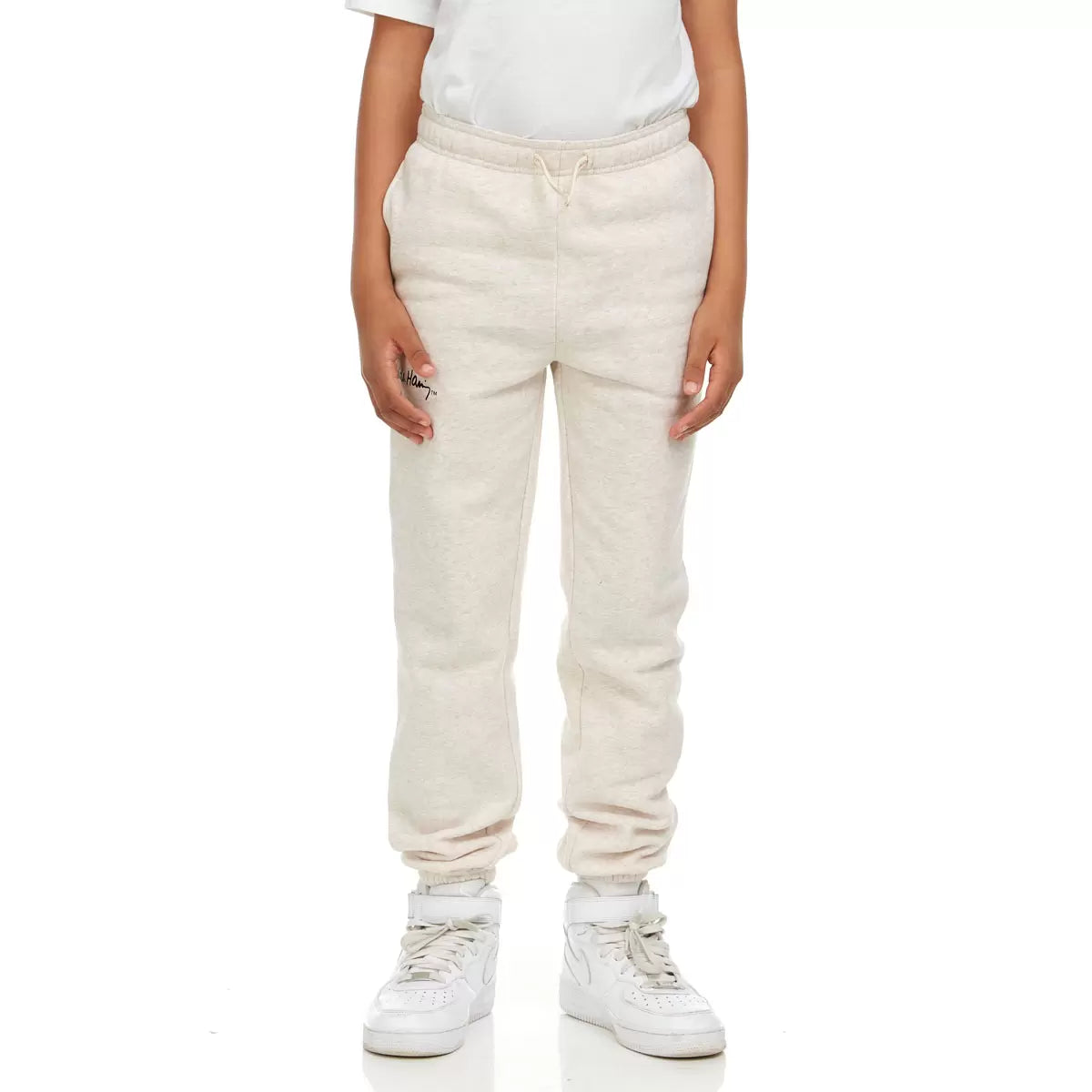 Front view of Keith Haring youth fleece joggers in green showing iconic pop art graphics, side pockets, and an elastic drawstring waistband.