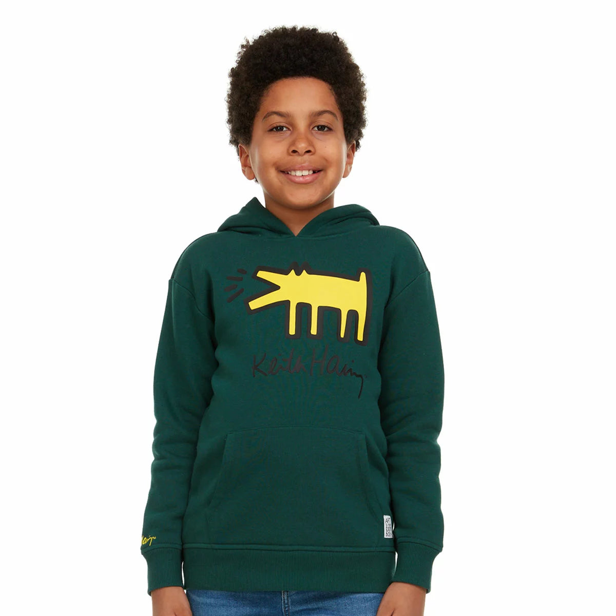 Close-up of the beige Keith Haring youth fleece hoodie showcasing the graphic front artwork, lined hood, and front kangaroo pocket on a neutral background.Close-up of the beige Keith Haring youth fleece hoodie showcasing the graphic front artwork, lined hood, and front kangaroo pocket on a neutral background.