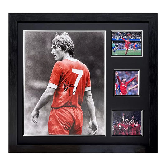 A framed, authentic photograph of Kenny Dalglish in his Liverpool kit, set in a professional black display frame against a clean background.