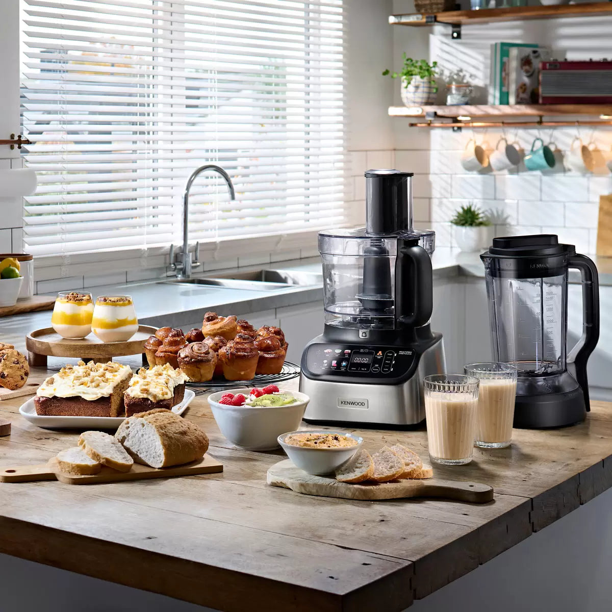 The Kenwood MultiPro OneTouch FDM73.480SS processor and blender in a modern kitchen, featuring the digital scale interface and various included attachments.