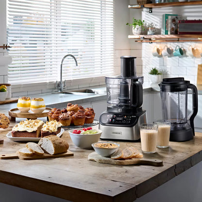 The Kenwood MultiPro OneTouch FDM73.480SS processor and blender in a modern kitchen, featuring the digital scale interface and various included attachments.
