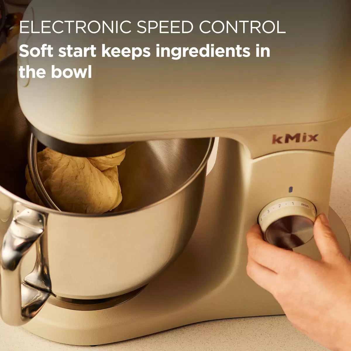 The cream Kenwood kMix KMX751ACR stand mixer shown with its 5L stainless steel bowl, K-beater, and splashguard on a bright kitchen work surface.