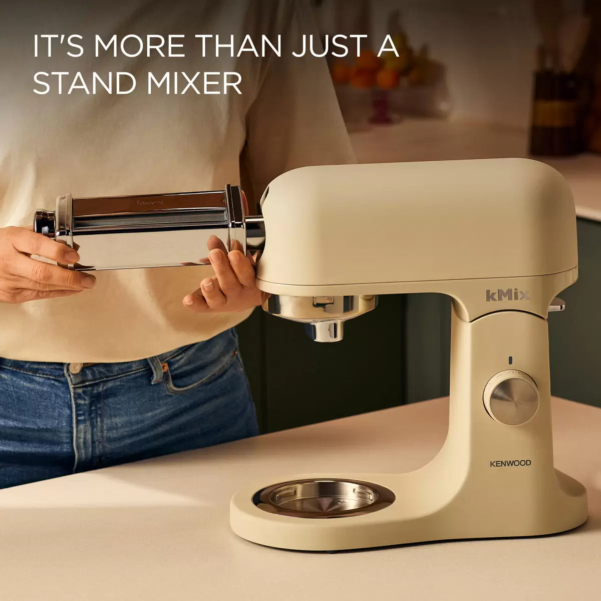 The cream Kenwood kMix KMX751ACR stand mixer shown with its 5L stainless steel bowl, K-beater, and splashguard on a bright kitchen work surface.