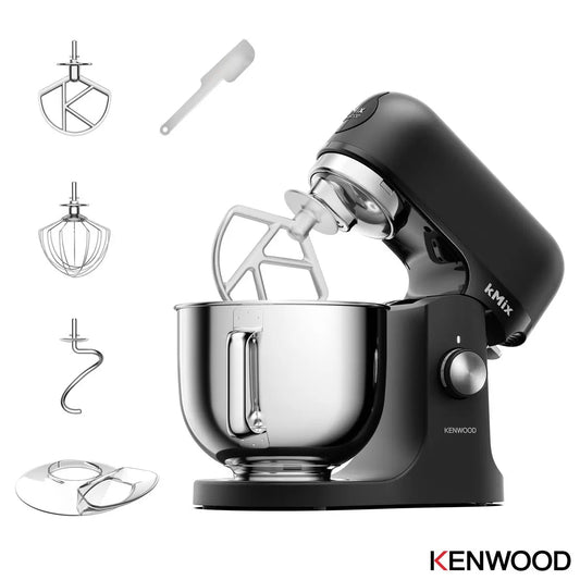 Front profile view of the Kenwood kMix KMX751ABK stand mixer in a matte black finish with its 5-litre stainless steel bowl and K-Beater attachment set up on a kitchen countertop.