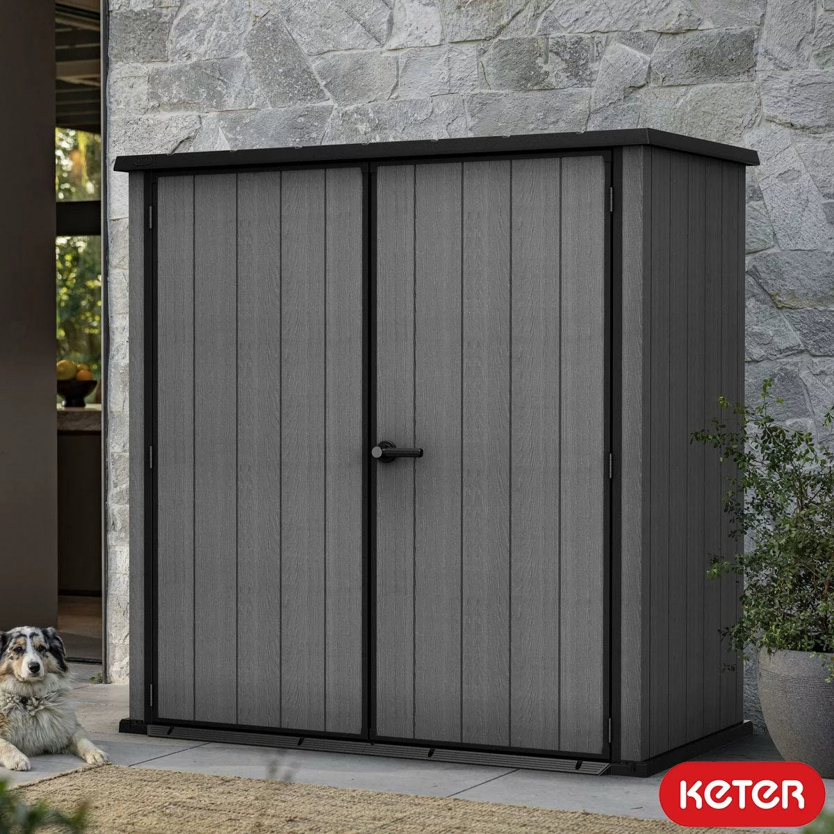 Keter Cortina 3000L extra-large vertical storage shed with doors open, showcasing a spacious interior filled with garden tools on a patio.