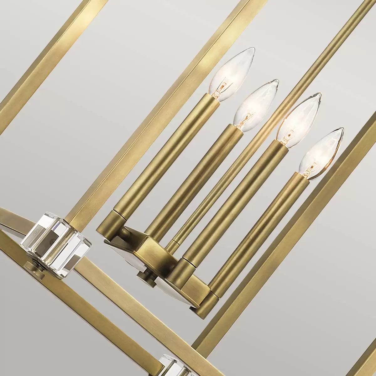 A large Kichler Cayden four-light pendant fixture featuring a gold natural brass steel cage with arched curves and clear optical crystal accents hanging from a high dining room ceiling.