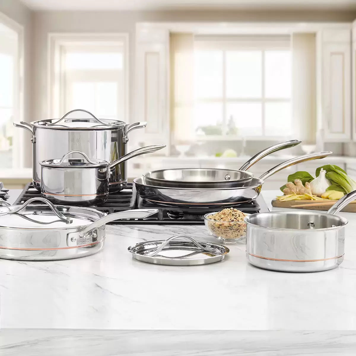 Kirkland Signature 10-piece stainless steel cookware set with copper core layers displayed on a modern kitchen countertop showing saucepans, stockpot, and skillets.