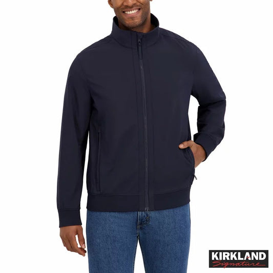 Kirkland Signature men's black softshell jacket featuring 4-way stretch fabric and zippered pockets displayed on a model outdoors.