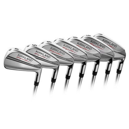 Side angle view of the chrome-finished Kirkland Signature stiff flex irons arranged neatly inside a premium leather golf bag on a manicured grass practice tee.