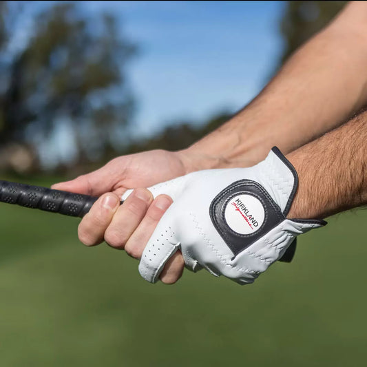 Four pristine white Kirkland Signature Cabretta leather golf gloves displayed flat, showing fine stitching details and adjustable wrist closure tabs.sd