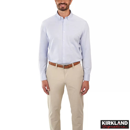 Front view of a man wearing the grey Kirkland Signature Knit Dress Shirt with a spread collar in a bright modern studio setting.