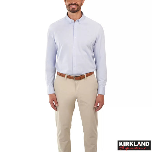 Front view of a man wearing the grey Kirkland Signature Knit Dress Shirt with a spread collar in a bright modern studio setting.