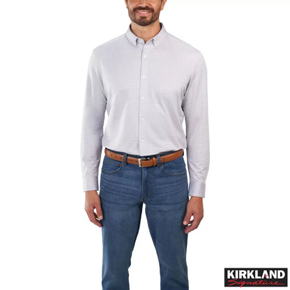 Front view of a man wearing the grey Kirkland Signature Knit Dress Shirt with a spread collar in a bright modern studio setting.