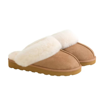 Pair of tan chestnut Kirkland Signature Women's Shearling Slippers featuring plush white wool lining resting on a light wooden floor.