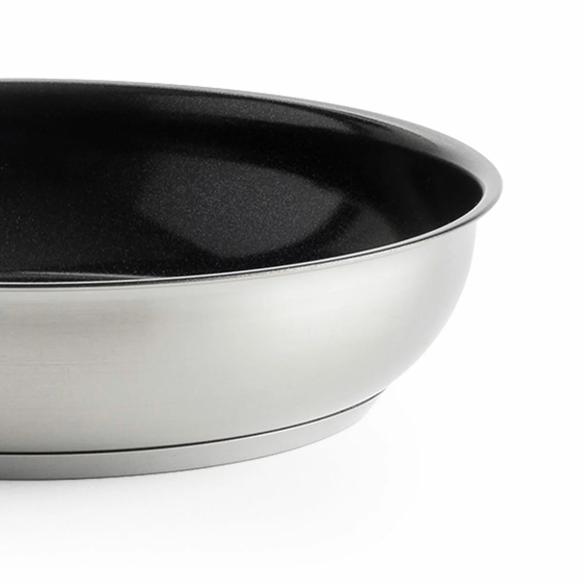 Close-up of the KitchenAid stainless steel pan featuring the ceramic non-stick surface and induction base.