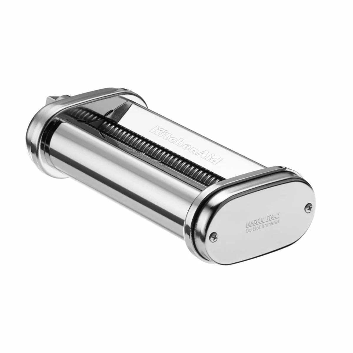 A silver KitchenAid 5KSMPRA pasta attachment set, featuring the roller and two cutters, neatly arranged on a clean kitchen counter next to a stand mixer.