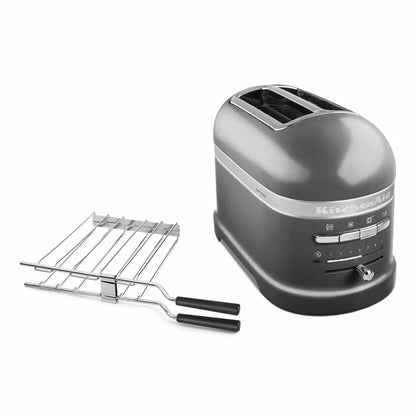 Front angle view of the die-cast KitchenAid Artisan 2-slot toaster on a modern wooden kitchen countertop alongside a toasted sandwich on the included stainless steel rack.