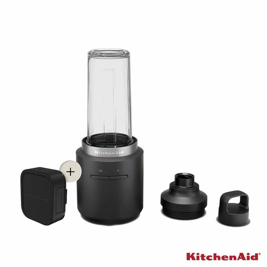 Matte black KitchenAid 5KSBR256BM Go Cordless Personal Blender with battery attached standing upright on a clean quartz kitchen counter next to its travel lid.