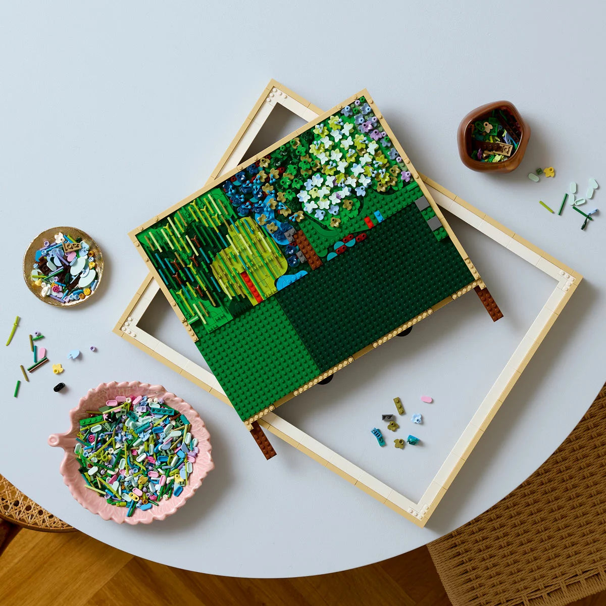 Front view of the built LEGO 31220 Claude Monet Water Lilies 3D wall art framed painting showing a light green bridge over a pond full of colorful textured flowers.