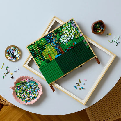 Front view of the built LEGO 31220 Claude Monet Water Lilies 3D wall art framed painting showing a light green bridge over a pond full of colorful textured flowers.
