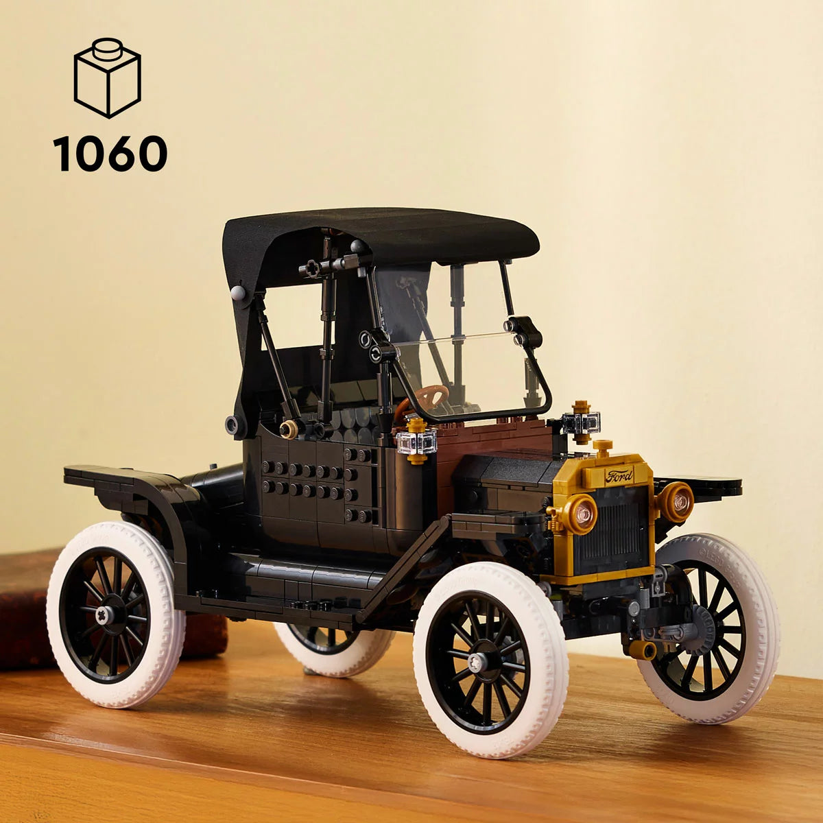 Three-quarter studio view of the built black LEGO Icons 11376 Ford Model T car display piece with gold trims, spoked wheels, white tyres, and an open driver's door.