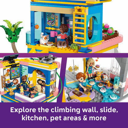 Front angle view of the colorful multi-story LEGO Friends Heartlake City Club House 42689 set featuring a red slide, zipline, climbing wall, five mini-dolls, and three pet figures on a clean white surface.