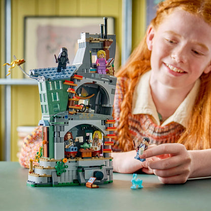 Front three-quarter angle of the eccentric cylindrical LEGO Harry Potter Luna Lovegood's House 76467 set displayed with five minifigures and a glowing light brick effect on a plain background.