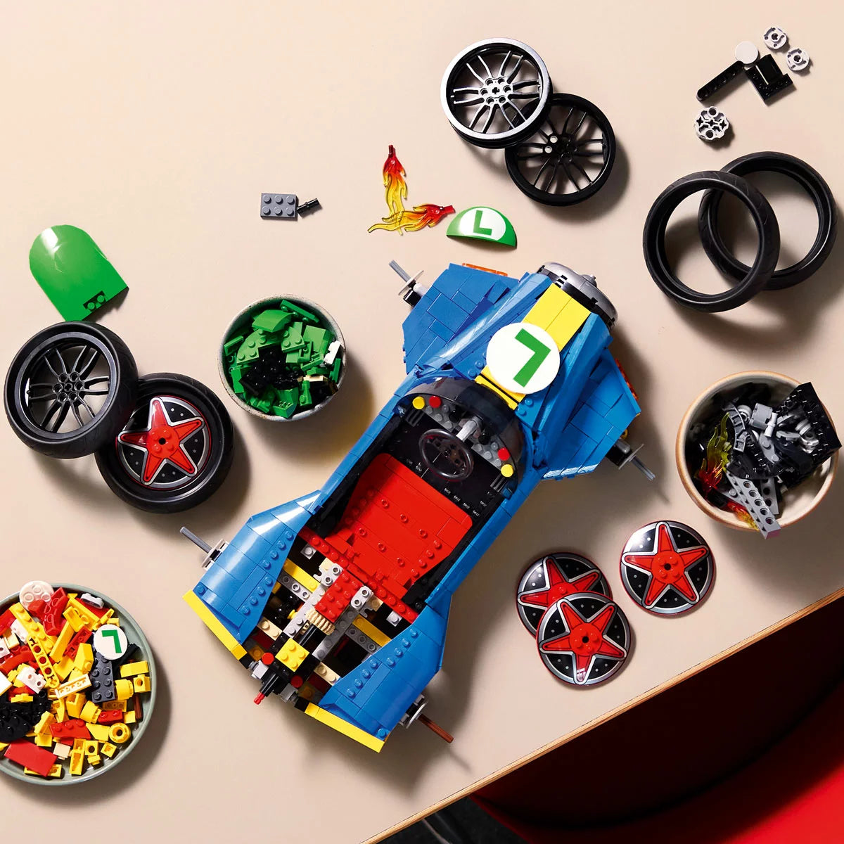 Three-quarter overhead shot of the large built blue and yellow LEGO 72050 Mach 8 racing kart with Luigi sitting inside, angled on a black display stand.
