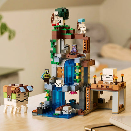 Front angle view of the LEGO Minecraft Ghast Station 21597 set featuring a blue waterfall, cave architecture, skeleton minifigures, and the white brick-built ghast blimp.