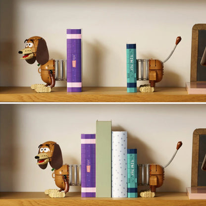 Three-quarter studio view of the built brown LEGO 43301 Slinky Dog bookends holding two blue and red brick-built books with a hidden Woody figure popping out.