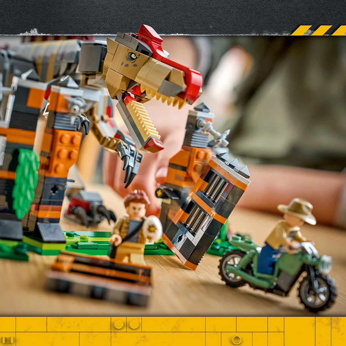 Front angle of the LEGO Jurassic World Spinosaurus dinosaur breaking through a grey brick enclosure gate next to a red getaway motorcycle.
